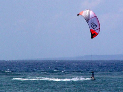 Kiteboarder gliding across the ocean near Sanur Beach Bali