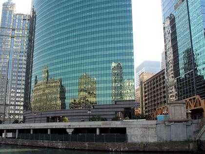Modern Chicago skyscrapers reflected in glass buildings along the Chicago River.