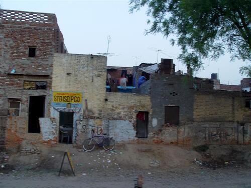 Commercial buildings and storefronts viewed from a train in northern India.
