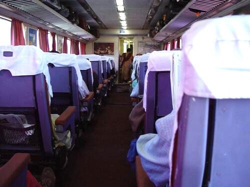 Interior of a first-class passenger train traveling through India.