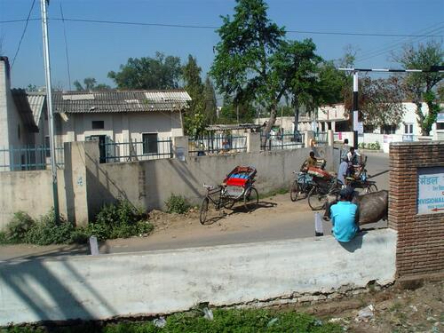 Rickshaws and bicycles waiting beside a railway crossing in northern India.