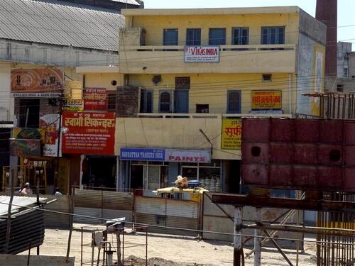 Village buildings and telephone shop viewed from a train in northern India.