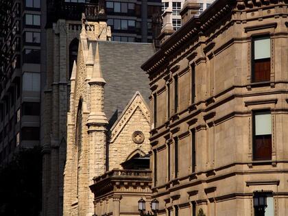 Historic church architecture framed by modern downtown Chicago buildings.