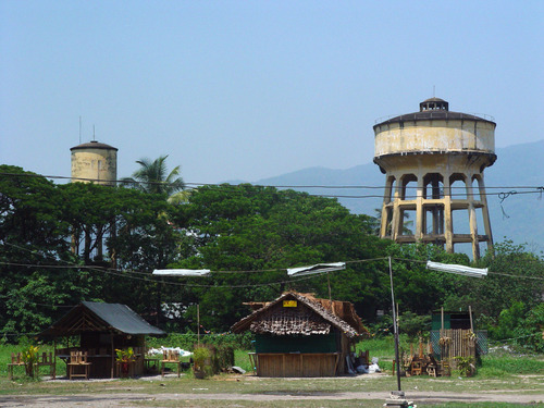 Traditional village buildings nestled among trees in rural northern Thailand.